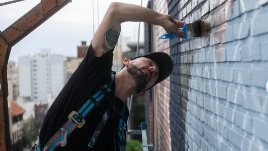 Ladrillo a ladrillo, así pinta Martín Ron su nuevo mural de Lionel Messi en la avenida 9 de Julio.
